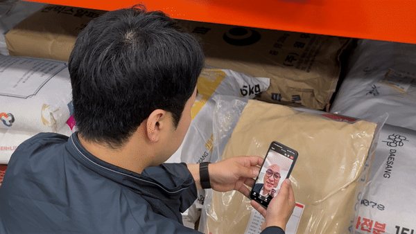 물류창고에서 교육 공간에 있는 동료와 네이버웍스 화상회의로 소통하는 모습.